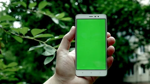 Close-up view of man hand swapping blank green screen of modern smartphone 스톡 동영상 91887383