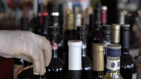 Close Up View Of Man Hands, Examines and Cleans Bottles of Wine. Video stock 129938240