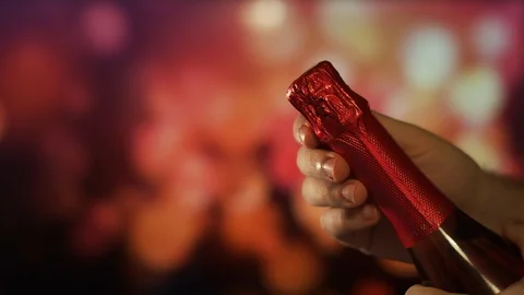 Close up view of man hands opening champagne bottle over Holiday Bokeh. Party Vidéo 121658933