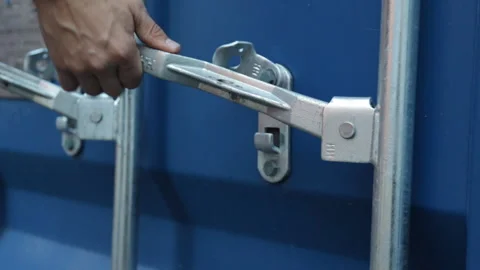 Close up view on man hands is opening the lock of large shipping container doors Stock Footage 252134059