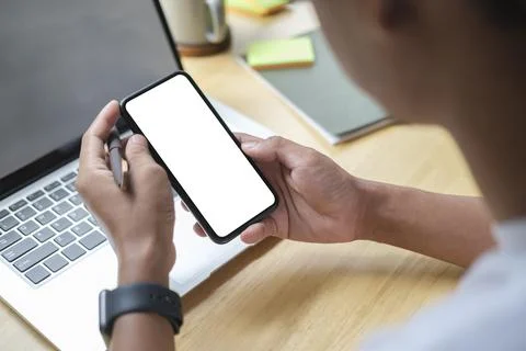 Close up view of man holding mock up smart phone with blank screen.. Stock-Fotos