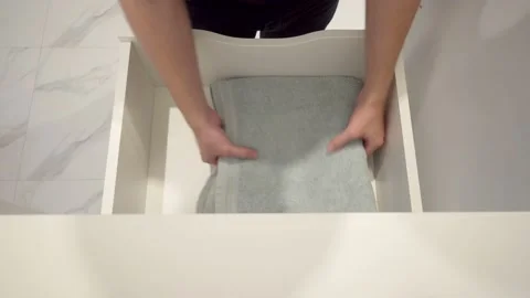 Close-up view of Man opened a drawer in the closet and took out a Bath Towel Stock Footage 132092698