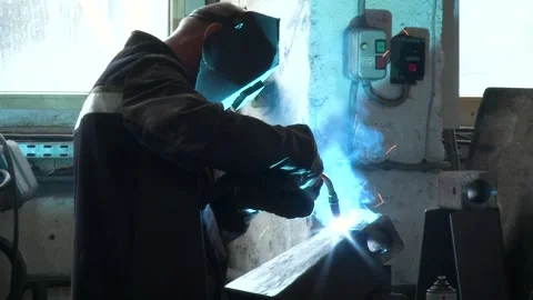 Close up view of a man in protective clothing in welding process of the iron Stock Footage 133347233