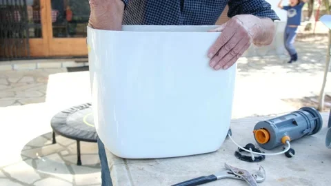 Close up view of man repair dirty rusty toilet tank outdoor Stock Footage 238400215