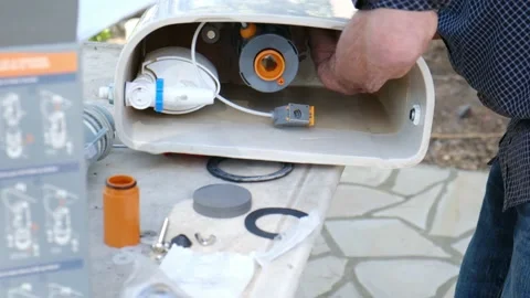Close up view of man repair dirty rusty toilet tank outdoor Stock Footage 238400264