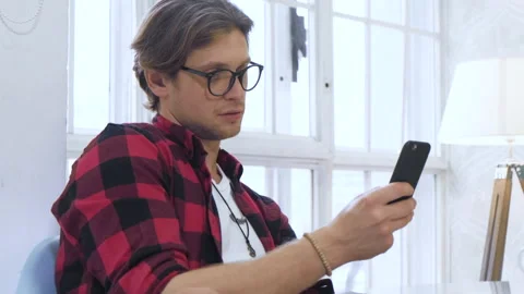 Close-up view of a man scrolling the feed in an app on his mobile phone Stock Footage 137093909