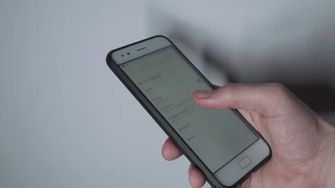 Close up view of man setting alarm clock on smartphone Stock Footage 122552262