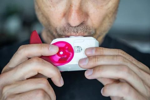 Close up view of man using medicine dry powder inhaler for treatment asthma or Stock Photos