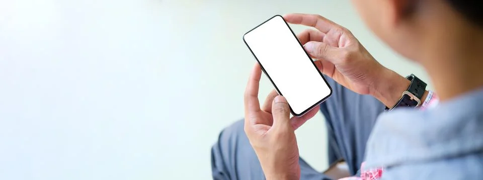 Close up view man using mobile phone in living room. Stock Photos