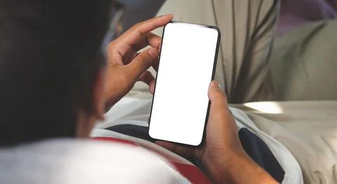 Close up view man using mobile phone while lying on couch at home. Stock Photos