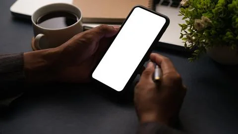 Close up view of man using smartphone at working desk. Blank screen mobile .. Foto stock