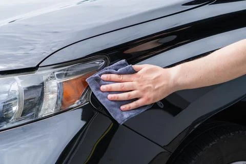 Close up view of a man using a soft grey microfiber cloth to clean and poli.. Stock Photos