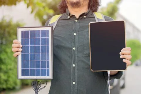 Close up view of man wear a backpack and hands charging his devices with po.. Foto stock