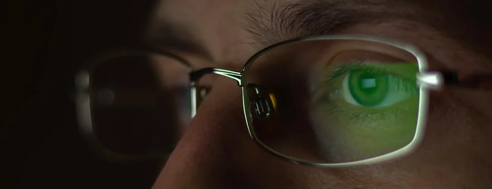 Close up view of man wears computer glasses for reducing eye strain blurred v Foto stock