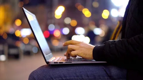 Close-up View of Man working at Laptop in the evening city street Stock Footage 97851672