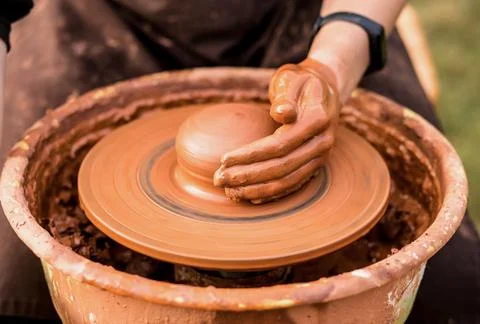 Close-up view of man working on pottery wheel and making clay pot outdoor 스톡 사진