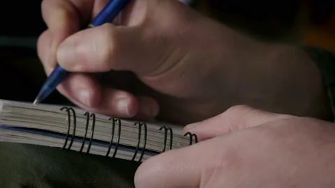 Close Up view of Man writing notes in notebook Stock Footage 152432081