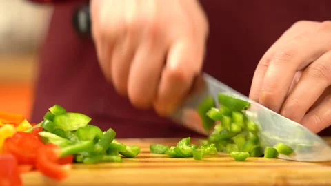 Close view man's hand chopping green fresh pepper with sharp knife. Video stock 146877457