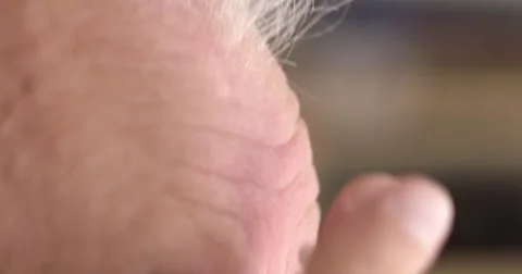 Close view of man's hand gently applying lotion to his forehead 4K Stock Footage 65059445