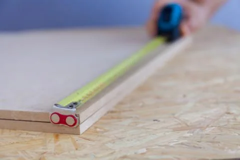 Close up view of a man's hand measuring wood with a tape. Handyman. Measurement Stock Photos