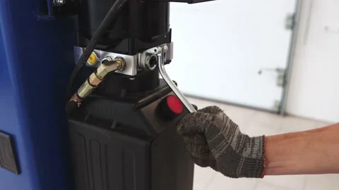 A close-up view of a man's hand raises a lever. The technician operates Stock Footage 165836152