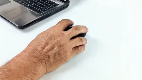 Close-up view of a man's hand using a wireless computer mouse on a desk, sc.. Stock Footage 338325699