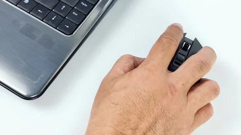 Close-up view of a man's hand using a wireless computer mouse on a desk, sc.. 스톡 동영상 338325913