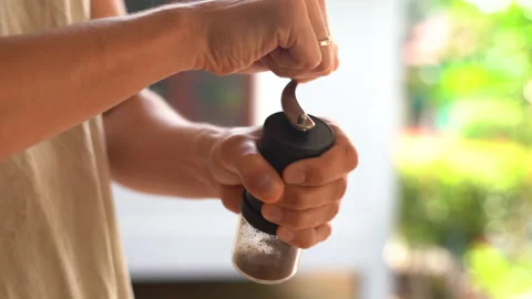 Close-up view of a man's hands grinding coffee beans in a manual coffee grinder Stock Footage 236699339