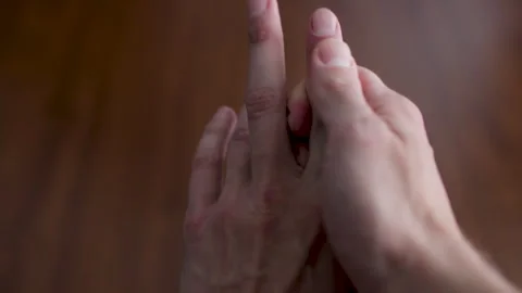 Close-up view of a man's hands performing a therapeutic self-massage on the palm Stock Footage 327158338