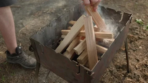 Close-up view of man's hands putting wooden beams for a campfire 스톡 동영상 265782119