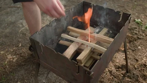 Close-up view of man's hands putting wooden beams for a campfire 스톡 동영상 265782132