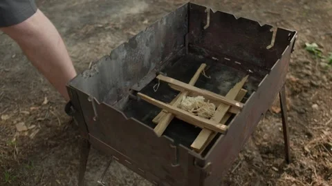 Close-up view of man's hands putting wooden beams for a campfire 스톡 동영상 265782163