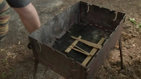 Close-up view of man's hands putting wooden beams for a campfire 스톡 동영상 265782187
