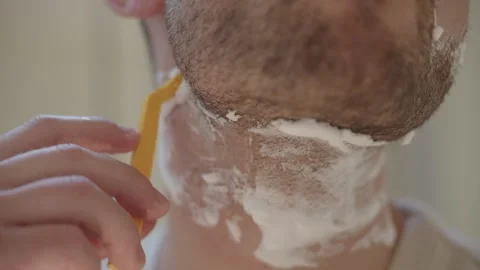 Close up view of a man's morning routine, shaving his neck with a disposable Stock Footage 335204172