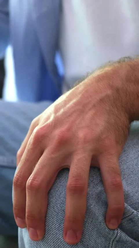 Close-up view of a man's restless hand nervously tapping his fingers on his Stock Footage 344781718