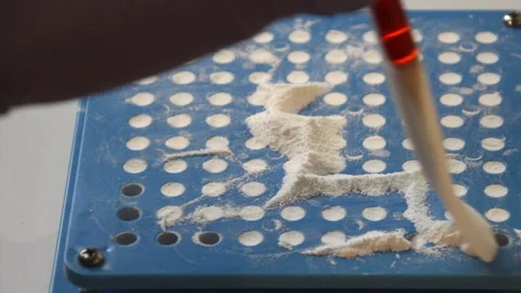 Close-up view of a manual capsule-making machine filling capsules with white Видео 327455599