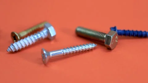 Close up view of many different screws placed on orange background Video stock 279526561
