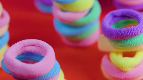 Close-Up View of Many Rotating Purple and Pink Rubber Bands on Orange Background Stock Footage 266900027