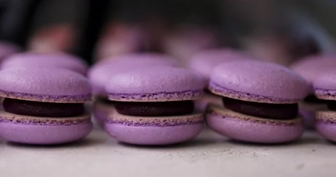 Close-up view of many rows of lilac macarons macaroon on white background Stock Footage 148786139