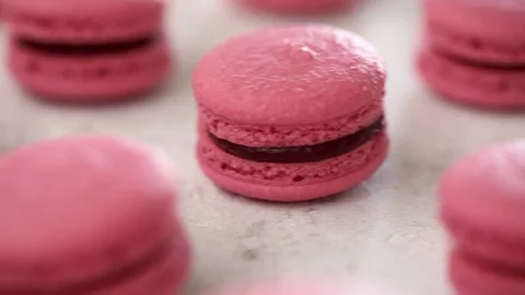 Close-up view of many rows of pink macarons macaroon on white background Video stock 129784165