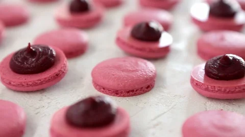 Close-up view of many rows of pink opened halves with filling macarons macaroon Video stock 129785341