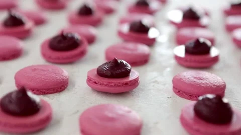 Close-up view of many rows of pink opened halves with filling macarons macaroon Stock Footage 130672998