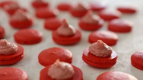 Close-up view of many rows of red opened halves with filling macarons macaroon Video stock 129785300