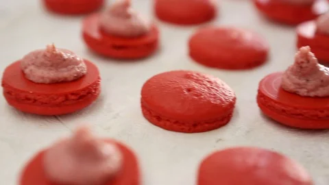 Close-up view of many rows of red opened halves with filling macarons macaroon Video stock 129917304