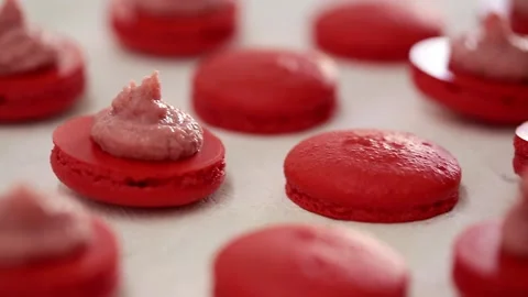Close-up view of many rows of red opened halves with filling macarons macaroon Vídeos de archivo 130238219