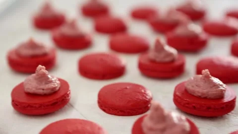 Close-up view of many rows of red opened halves with filling macarons macaroon Stock Footage 130983563