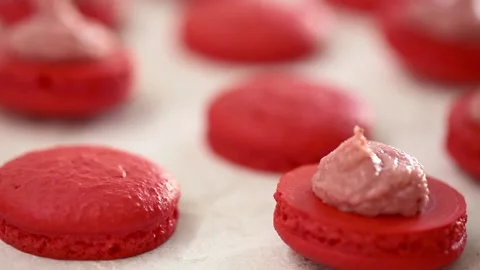 Close-up view of many rows of red opened halves with filling macarons macaroon Video stock 130983572