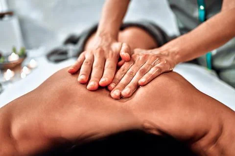 Close-up view masseur hands doing spin massage Stock Photos