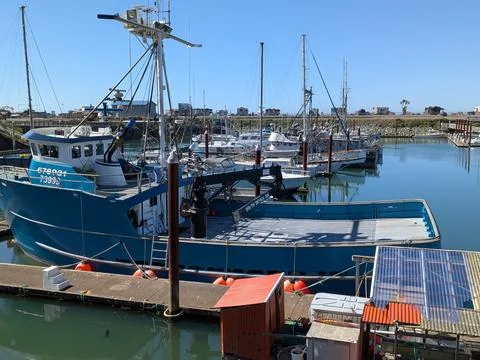 A close view of a massive blue ship with a black crane Stock Photos
