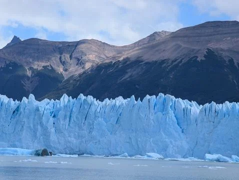 Close view of massive Perito Moreno glacier ice wall with mountain background 스톡 사진
